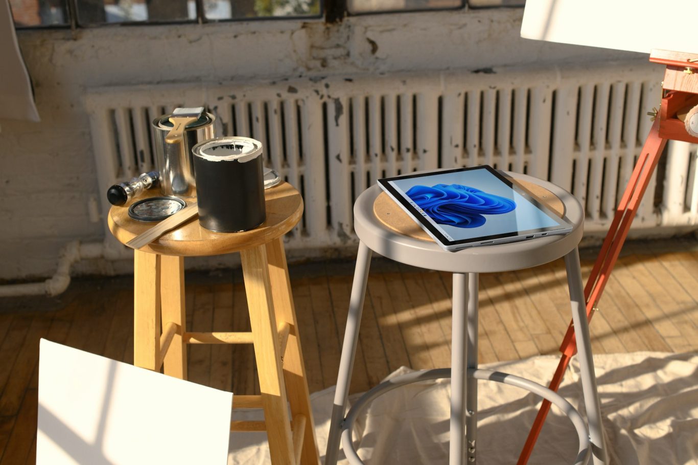 Atelier Holzmöbel und ein Tablet mit einer blauen Grafik in einem sonnigen Raum.